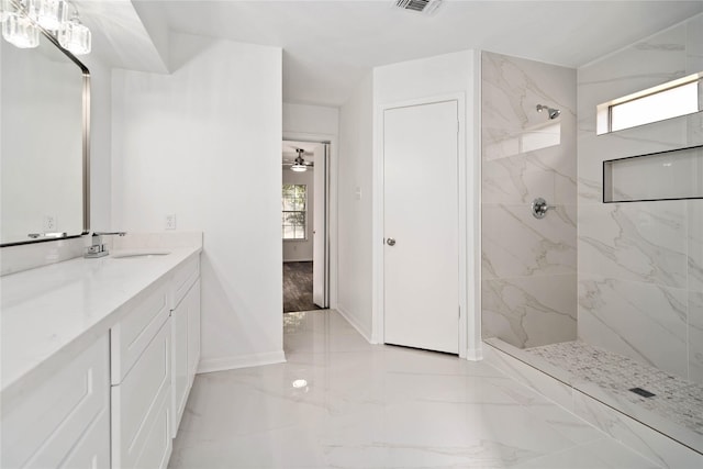 bathroom with vanity, ceiling fan, and tiled shower