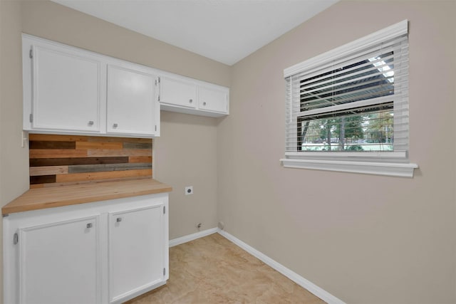 clothes washing area featuring cabinets and electric dryer hookup