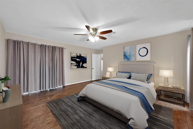 bedroom featuring ceiling fan, dark wood-type flooring, and a textured ceiling