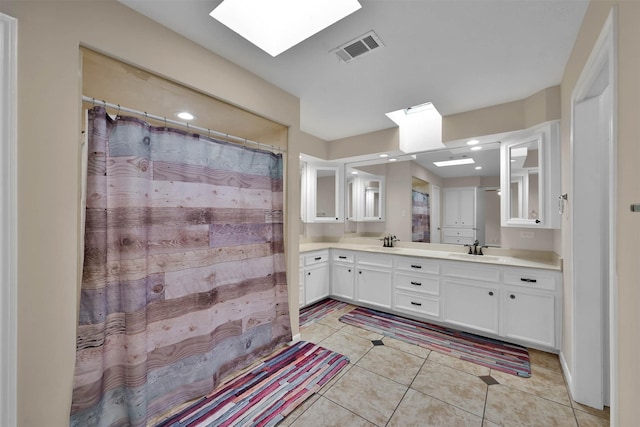 bathroom featuring tile patterned flooring, vanity, and a skylight