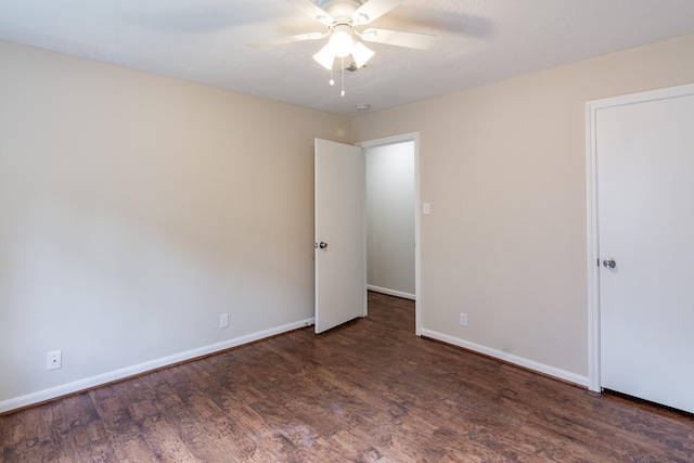 empty room featuring ceiling fan and dark wood-type flooring