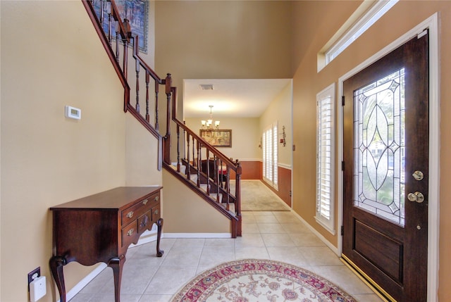 entryway with light tile patterned flooring and a chandelier