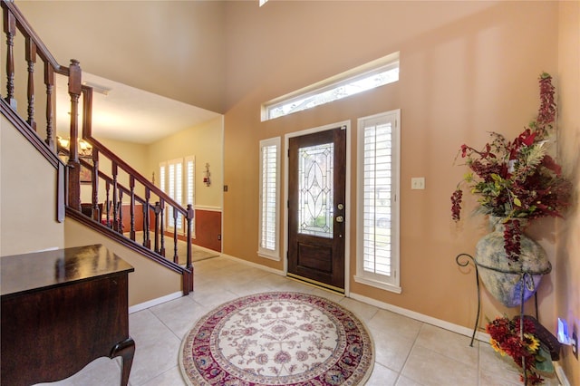 entrance foyer featuring light tile patterned floors and a high ceiling