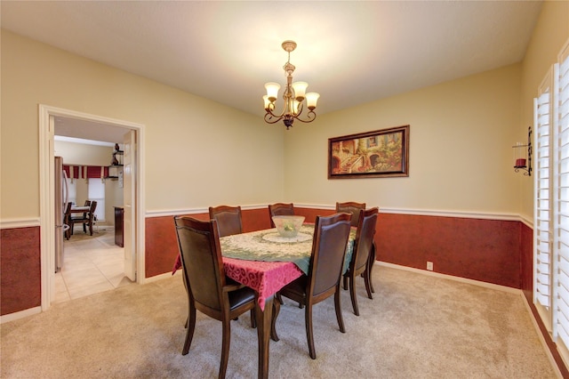 carpeted dining room featuring a notable chandelier