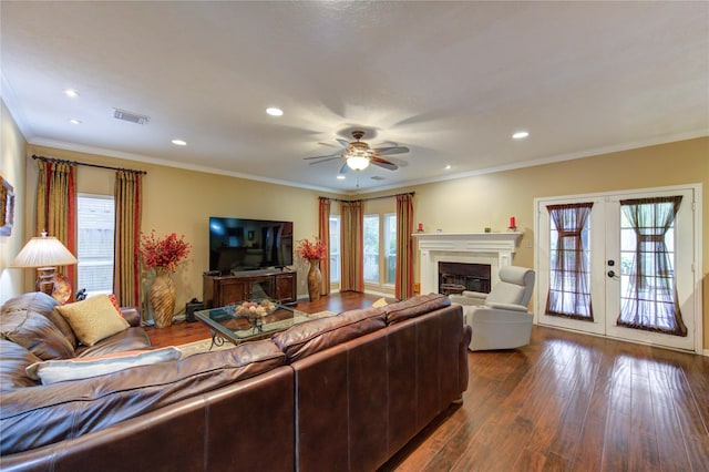 living room featuring plenty of natural light, ornamental molding, dark wood-type flooring, and french doors