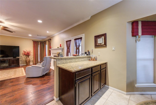 kitchen with ceiling fan, dark brown cabinetry, ornamental molding, light hardwood / wood-style floors, and kitchen peninsula