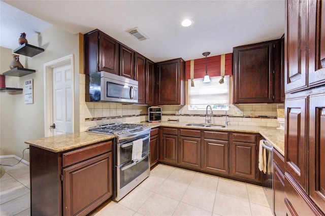 kitchen featuring kitchen peninsula, tasteful backsplash, stainless steel appliances, sink, and pendant lighting