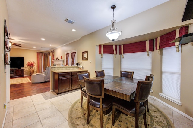 dining area featuring crown molding and light tile patterned flooring