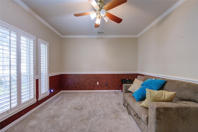 sitting room featuring ceiling fan, light colored carpet, and crown molding