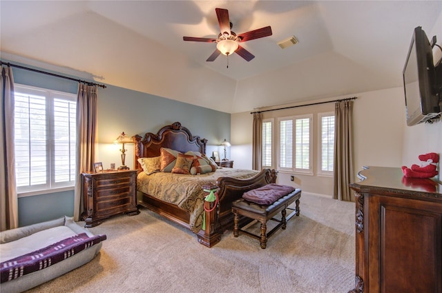 carpeted bedroom with a tray ceiling, ceiling fan, and lofted ceiling