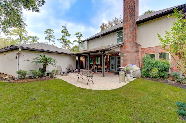 back of property featuring a lawn and a patio