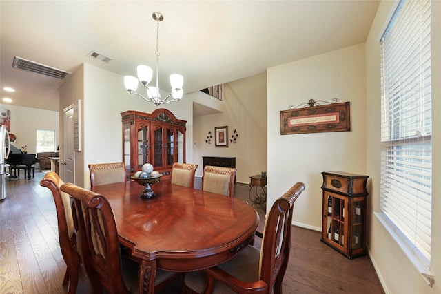 dining area with dark wood-type flooring and a notable chandelier