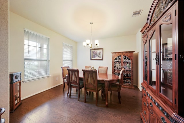 dining space with dark hardwood / wood-style flooring and a notable chandelier