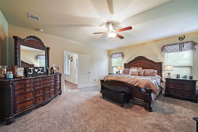 carpeted bedroom featuring a textured ceiling and ceiling fan