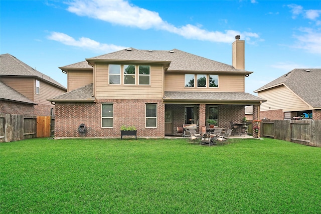 back of property with a patio area and a lawn