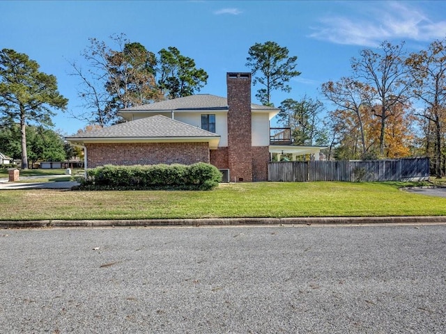 view of home's exterior with a balcony and a lawn