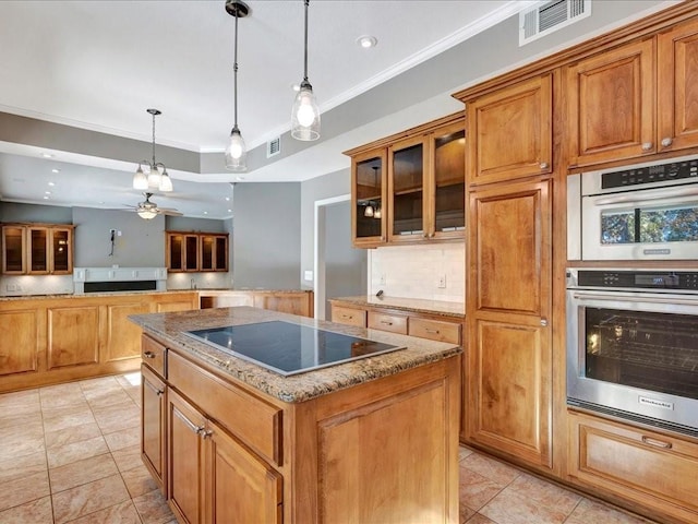 502 Crown Colony Dr, Lufkin, TX 75901 - kitchen featuring black electric cooktop, a kitchen island, brown cabinets, ornamental molding, and glass insert cabinets