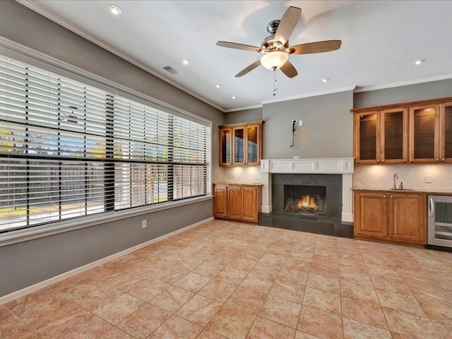 502 Crown Colony Dr, Lufkin, TX 75901 - unfurnished living room with plenty of natural light, beverage cooler, ornamental molding, a premium fireplace, and ceiling fan