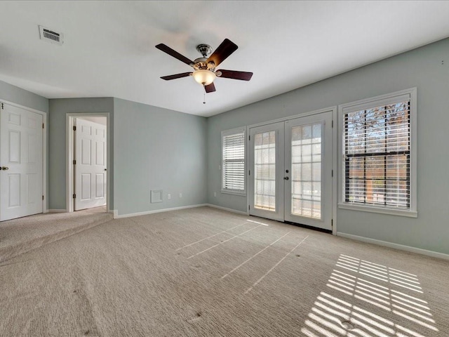 carpeted empty room with ceiling fan and french doors