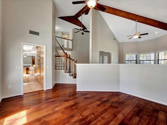 502 Crown Colony Dr, Lufkin, TX 75901 - unfurnished living room with high vaulted ceiling, a ceiling fan, wood finished floors, stairway, and beamed ceiling