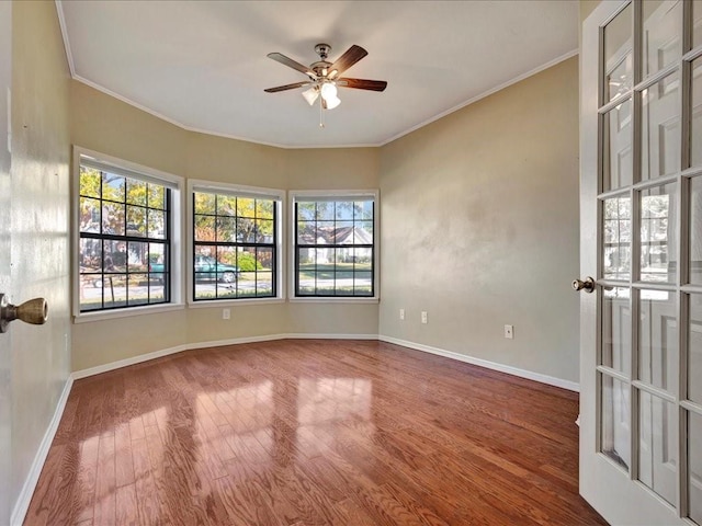 empty room featuring hardwood / wood-style flooring, plenty of natural light, and ornamental molding