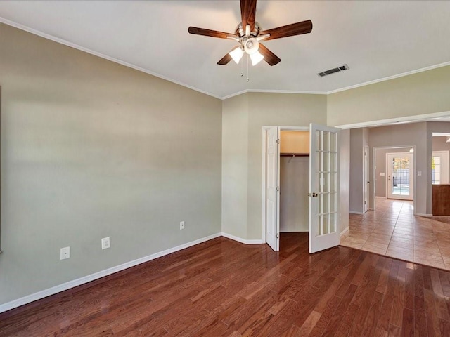 unfurnished bedroom with french doors, ceiling fan, crown molding, wood-type flooring, and a closet