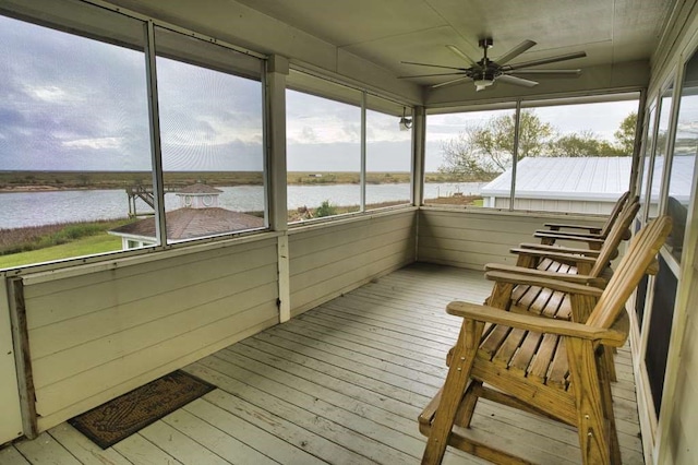 sunroom with a water view and ceiling fan