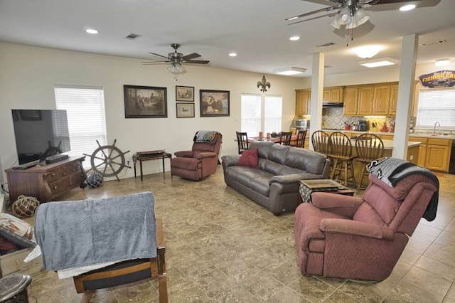 living room featuring ceiling fan, plenty of natural light, and sink