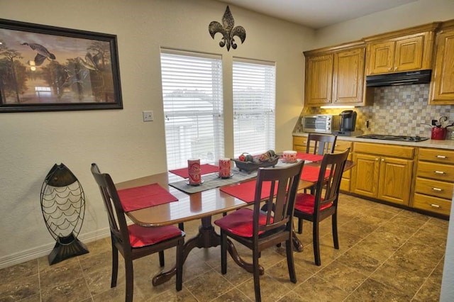 dining space with a toaster and baseboards