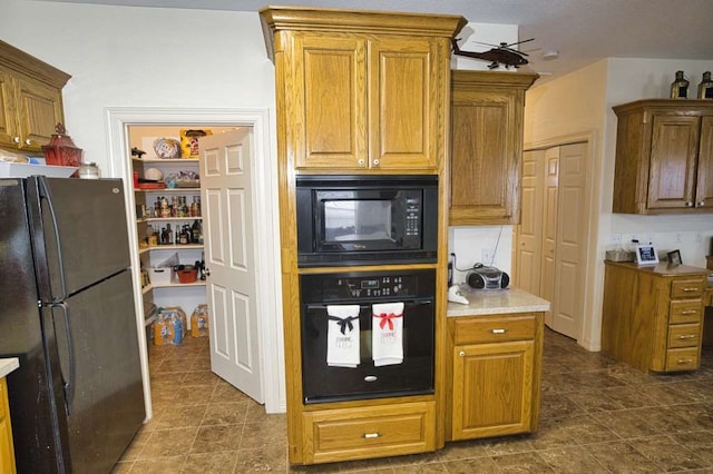 kitchen featuring light countertops, brown cabinets, ceiling fan, and black appliances