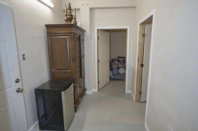 hall with finished concrete floors and baseboards