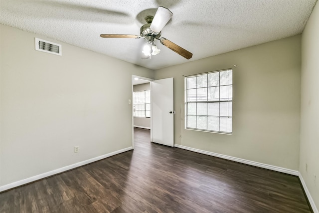 empty room featuring ceiling fan, dark hardwood / wood-style flooring, and a textured ceiling