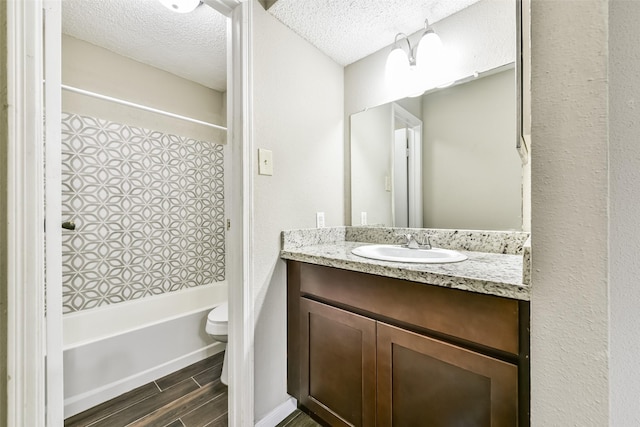 full bathroom with a textured ceiling, vanity, shower / bathing tub combination, wood-type flooring, and toilet