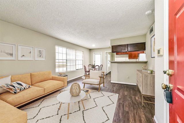 living room featuring a textured ceiling and dark hardwood / wood-style flooring