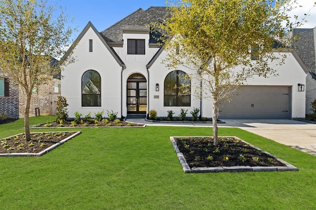 view of front of property with french doors, a garage, and a front lawn