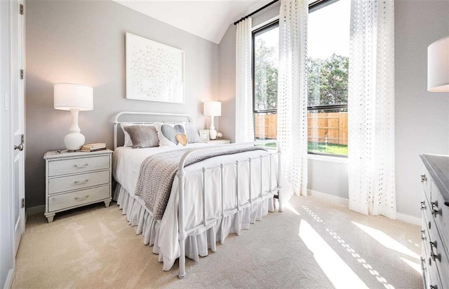 bedroom with vaulted ceiling and light carpet