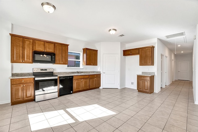 kitchen with light stone countertops, sink, light tile patterned floors, and black appliances