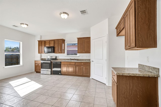 kitchen with light tile patterned floors, sink, and black appliances