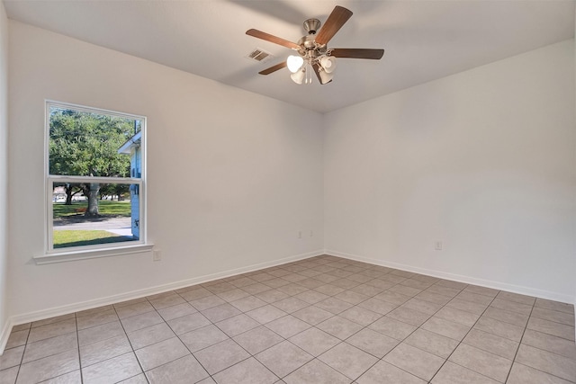 empty room with ceiling fan and light tile patterned flooring