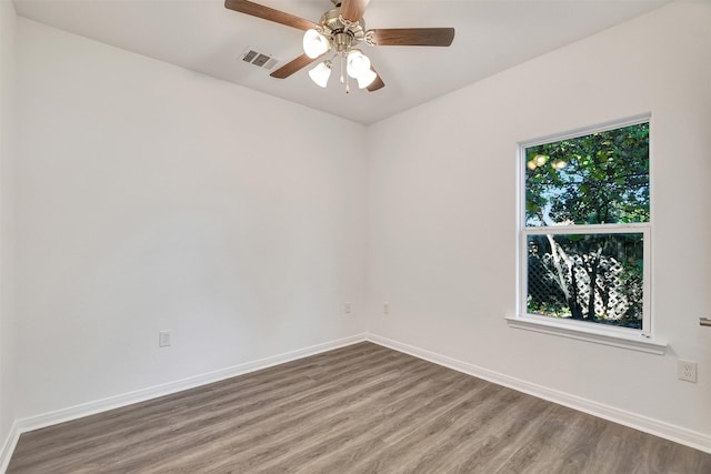 unfurnished room featuring a wealth of natural light, hardwood / wood-style floors, and ceiling fan