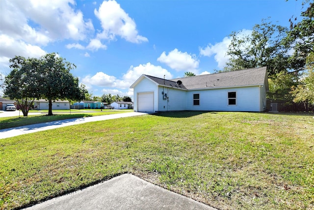 view of side of home with a lawn, central AC, and a garage