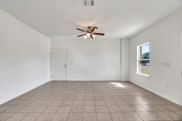 tiled spare room with ceiling fan