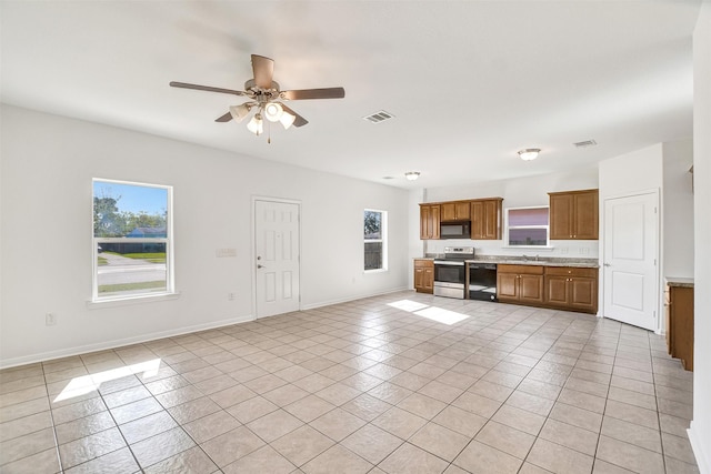 kitchen with black appliances, a healthy amount of sunlight, and light tile patterned floors