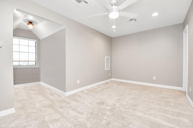 carpeted spare room featuring ceiling fan and vaulted ceiling