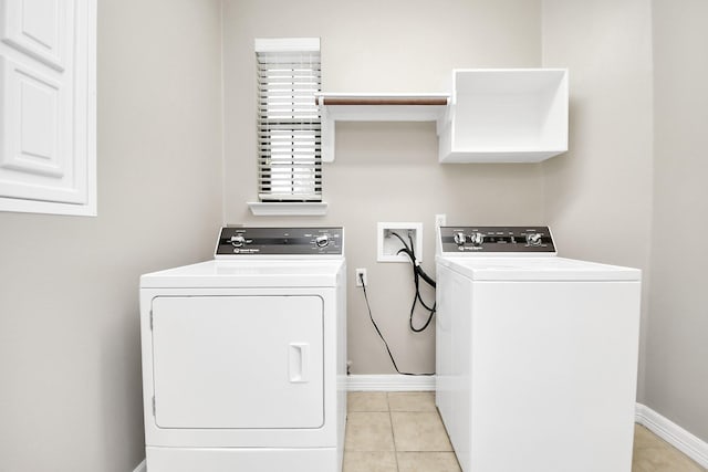 clothes washing area featuring light tile patterned flooring and washing machine and clothes dryer