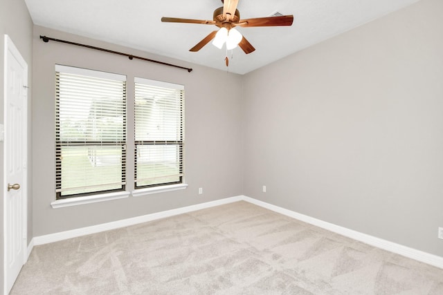 carpeted spare room with ceiling fan