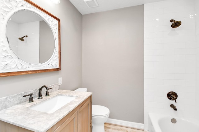 full bathroom with hardwood / wood-style flooring, tiled shower / bath combo, toilet, and vanity