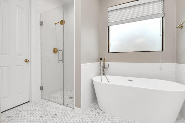 bathroom featuring tile patterned flooring, separate shower and tub, and tile walls