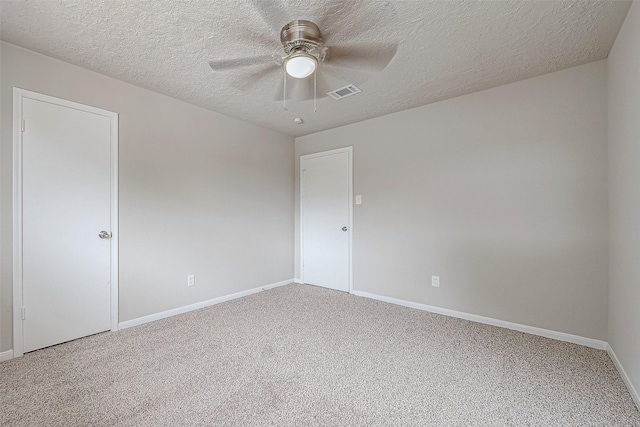 carpeted empty room with ceiling fan and a textured ceiling