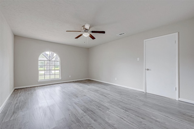 unfurnished room with a textured ceiling, light hardwood / wood-style flooring, and ceiling fan